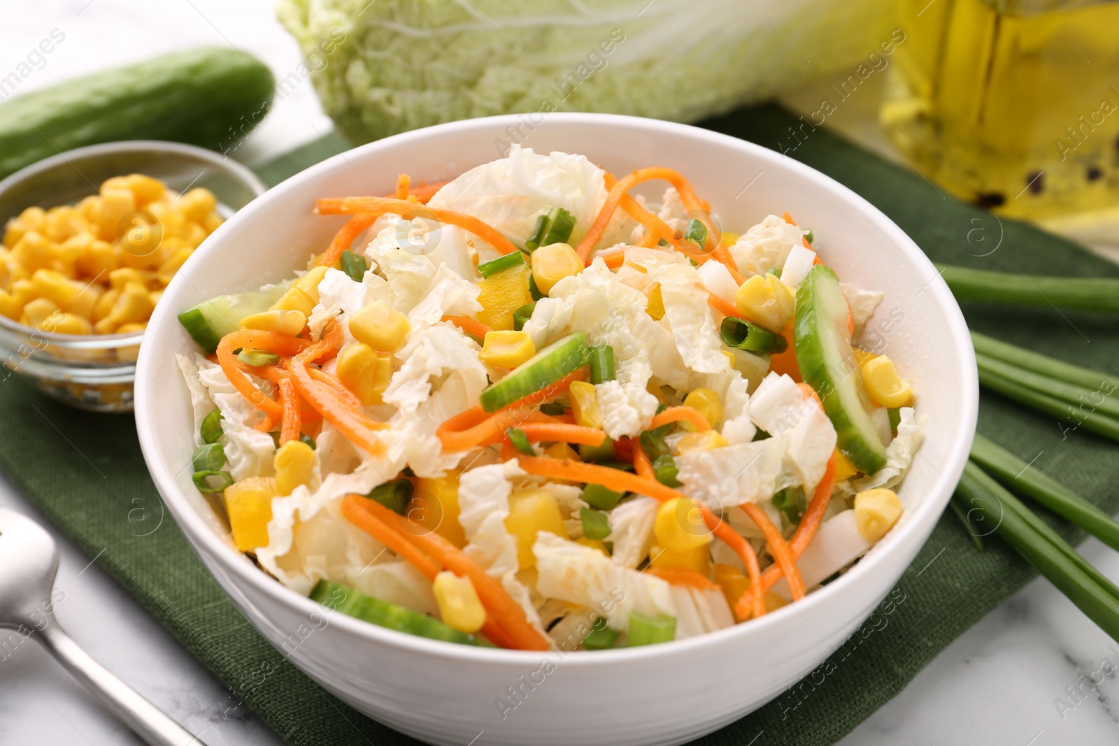 Photo of Tasty salad with Chinese cabbage, carrot, corn and cucumber in bowl on table, closeup