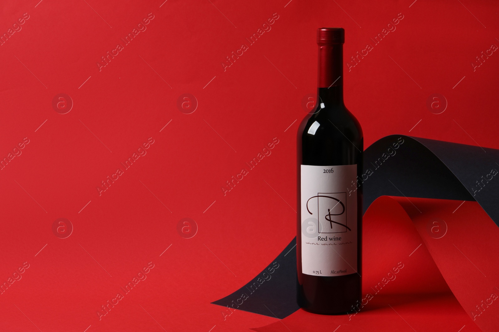 Photo of Bottle of delicious red wine on color background, space for text