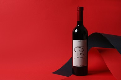 Photo of Bottle of delicious red wine on color background, space for text