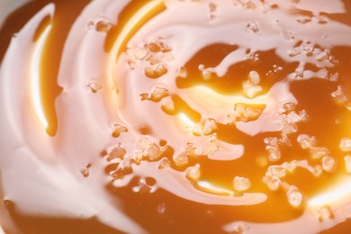 Delicious caramel sauce with sea salt as background, closeup