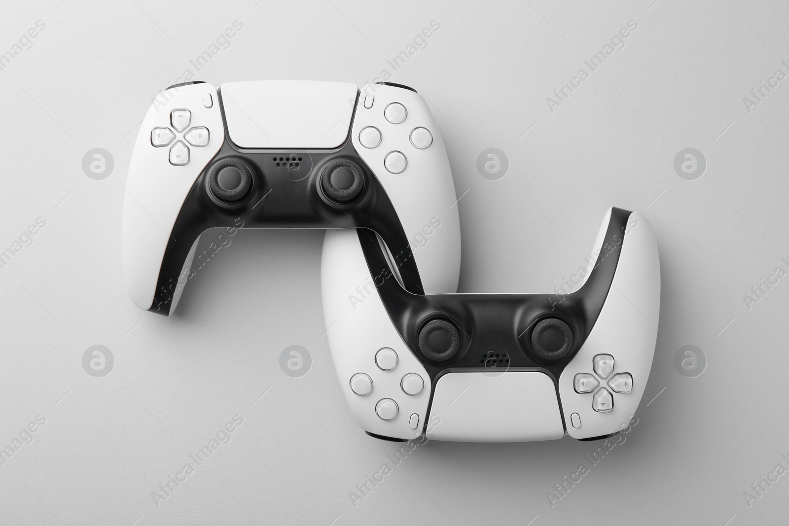 Photo of Wireless game controllers on light grey background, flat lay