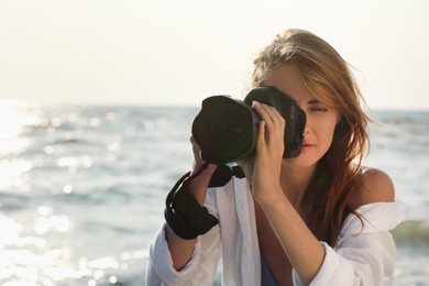 Photo of Photographer taking photo with professional camera near sea