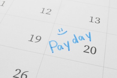 Calendar page with marked payday date as background, closeup