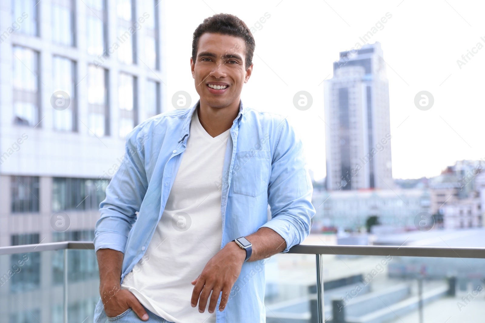 Photo of Handsome young African-American man on city street. Space for text