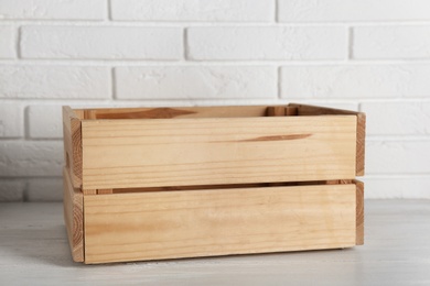 Wooden crate on table near brick wall