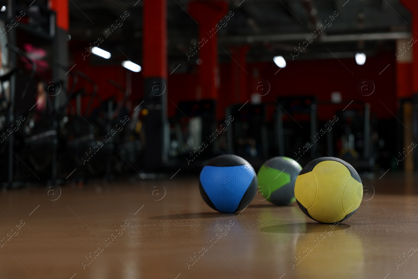 Photo of Medicine balls on floor in gym. Space for text