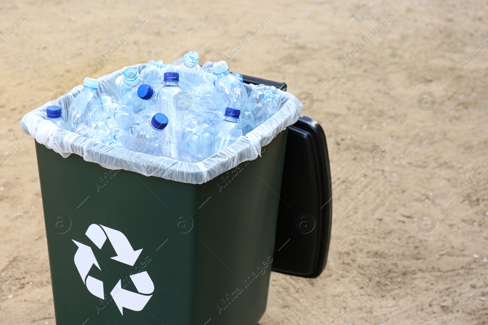 Photo of Many used plastic bottles in trash bin outdoors. Recycling problem