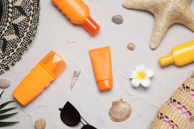 Flat lay composition with sun protection products on sand