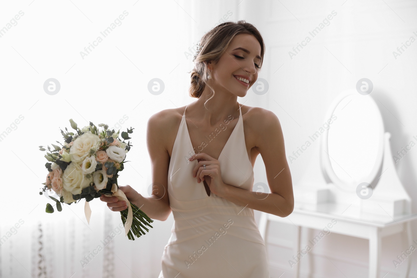 Photo of Bride in beautiful wedding dress with bouquet indoors