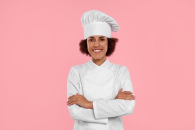 Photo of Portrait of happy female chef in uniform on pink background