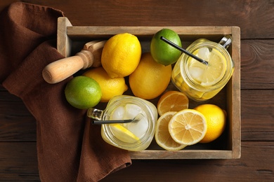Photo of Mason jars with natural lemonade in wooden crate, top view