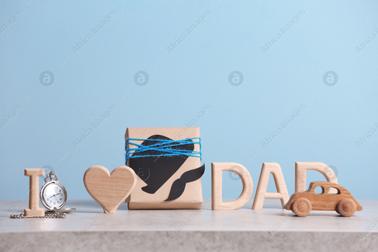 Photo of Composition with gift box and clock on table. Father's day celebration