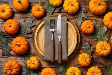 Photo of Happy Thanksgiving day. Autumn table setting, pumpkins and dry leaves on wooden background, flat lay