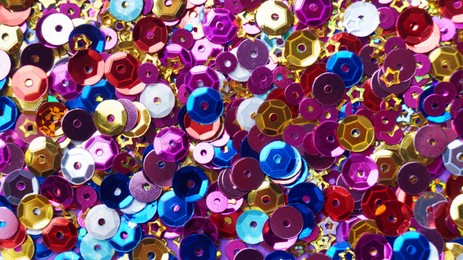 Photo of Many different colorful sequins as background, top view