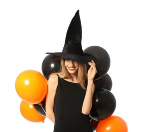 Beautiful woman wearing witch costume with balloons for Halloween party on white background