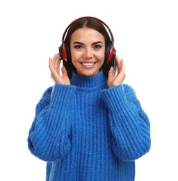 Young woman listening to music with headphones on white background