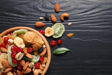 Photo of Flat lay composition of different dried fruits and nuts on color wooden background. Space for text