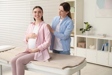 Photo of Doula taking care of pregnant woman indoors. Preparation for child birth