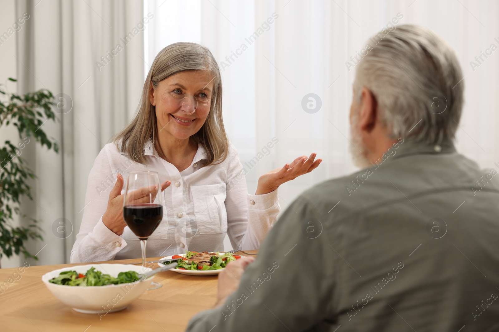 Photo of Happy senior couple having romantic dinner at home