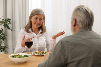 Happy senior couple having romantic dinner at home