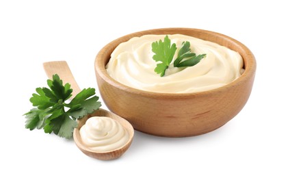 Spoon and bowl of delicious mayonnaise with parsley on white background