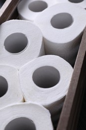 Photo of Many toilet paper rolls in wooden crate