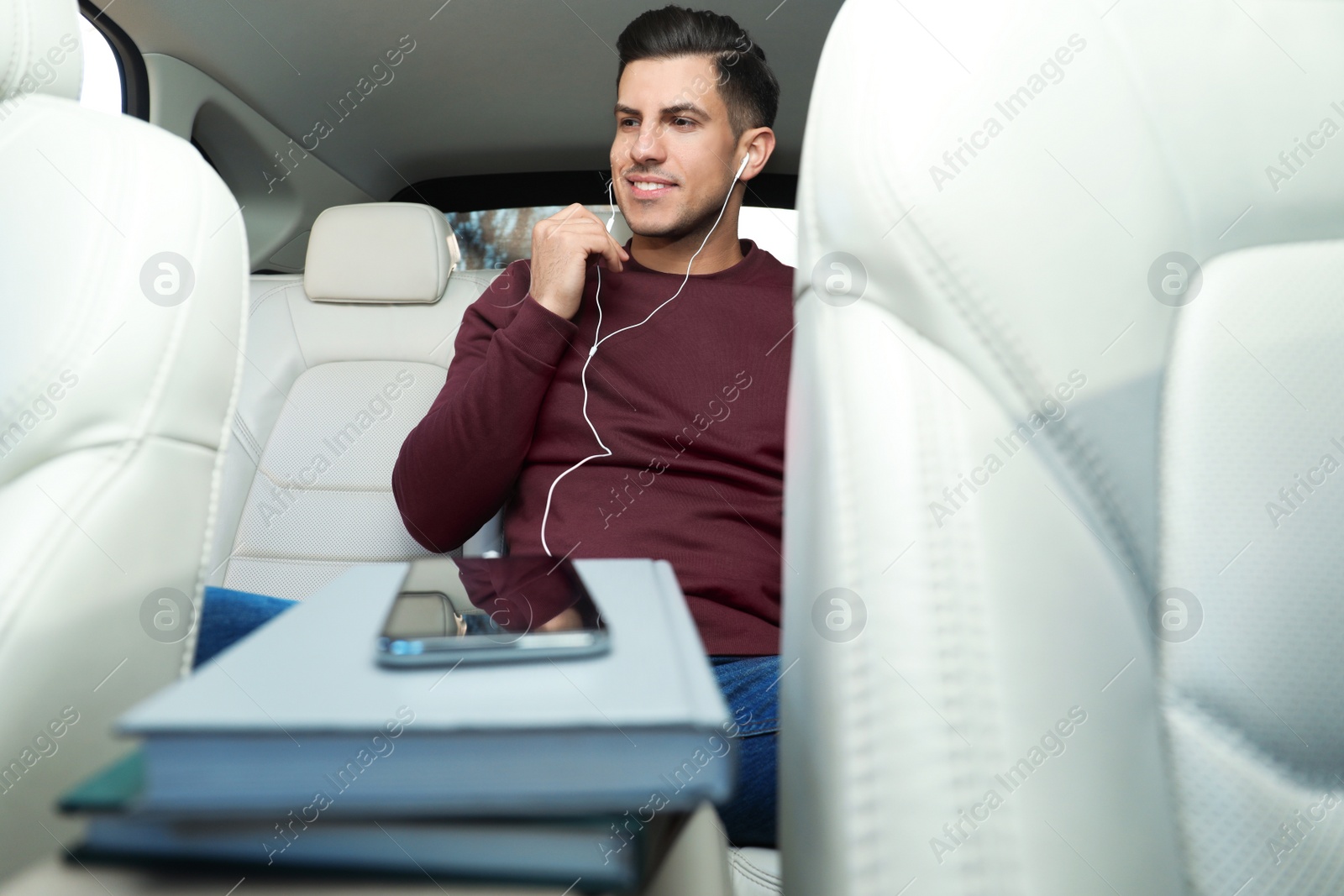 Photo of Man with mobile phone listening to audiobook in car