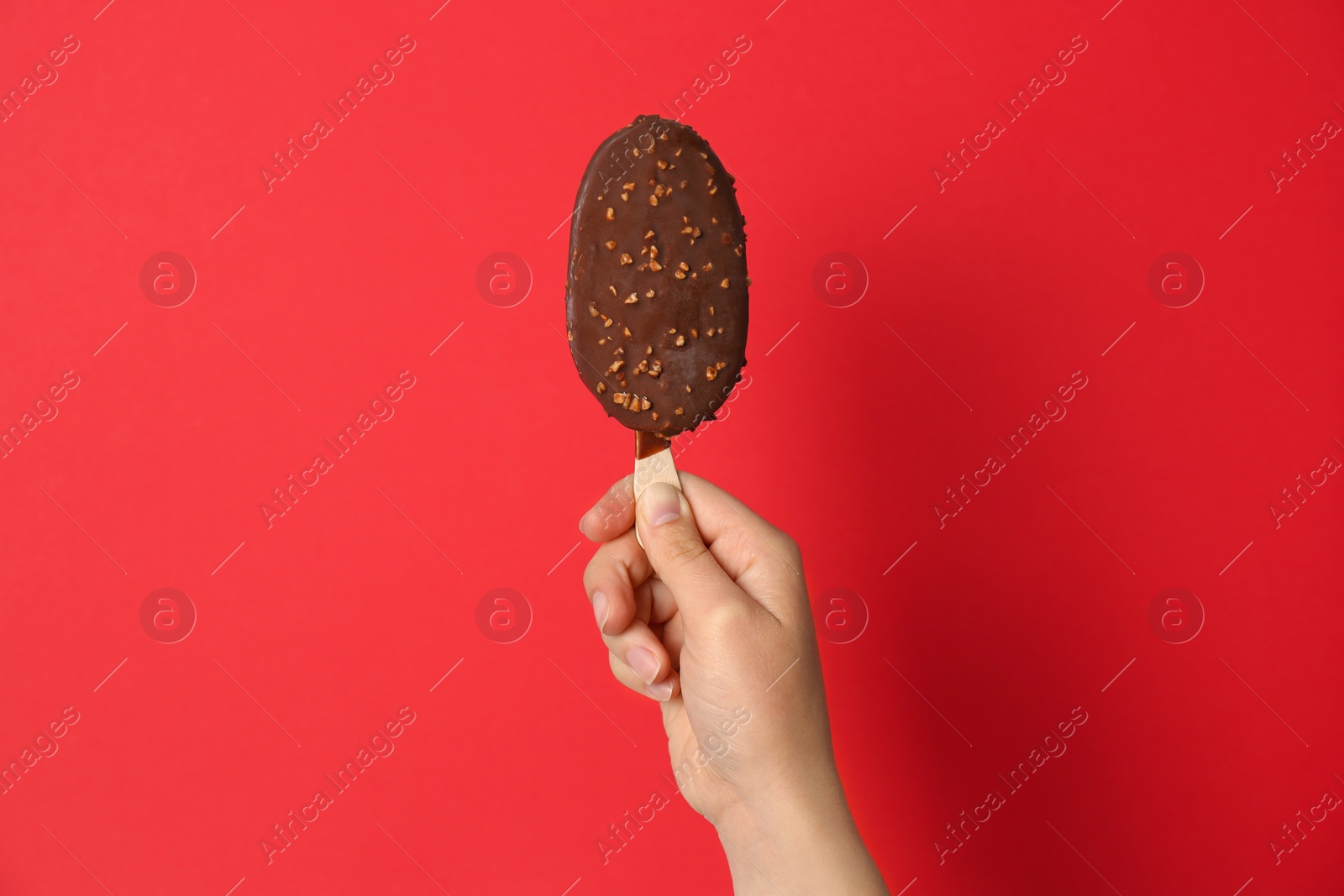 Photo of Woman holding delicious ice cream with chocolate against color background