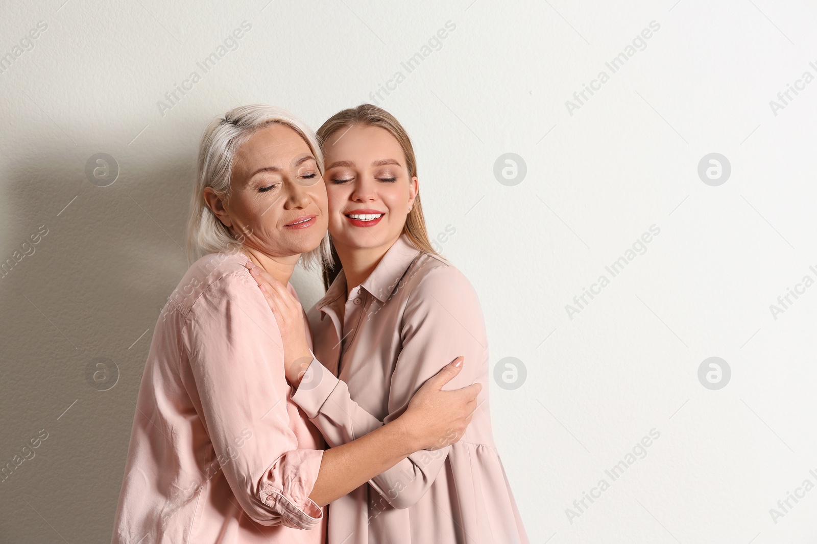 Photo of Mother and her adult daughter on white background. Space for text