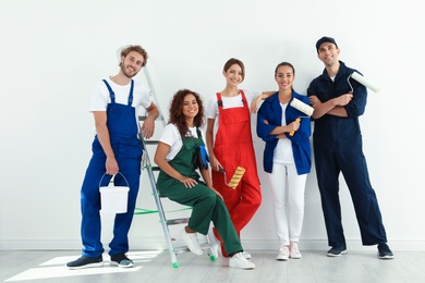 Photo of Team of professional painters with tools indoors