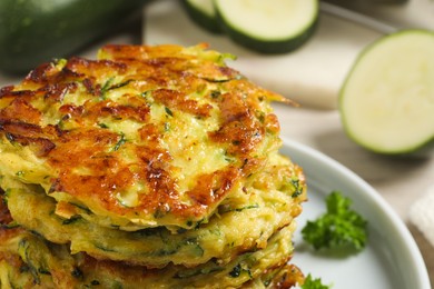 Photo of Delicious zucchini fritters on plate, closeup view