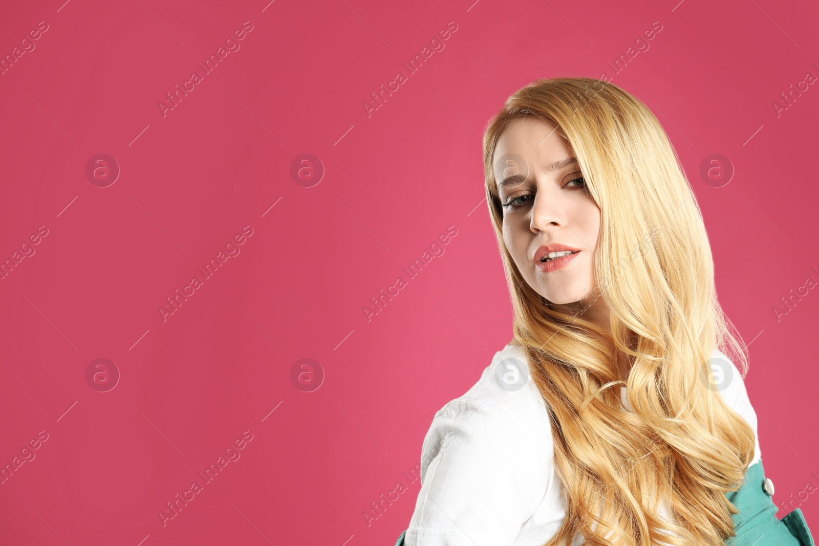 Photo of Portrait of beautiful young woman with dyed long hair on pink background. Space for text