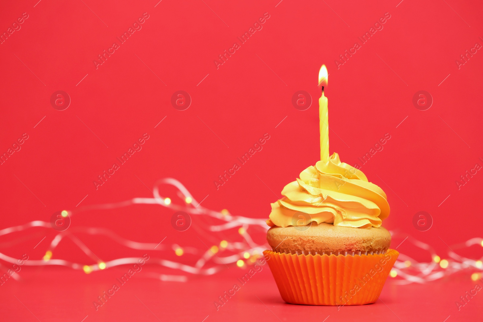 Photo of Birthday cupcake with candle on color background