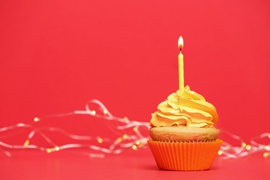 Photo of Birthday cupcake with candle on color background