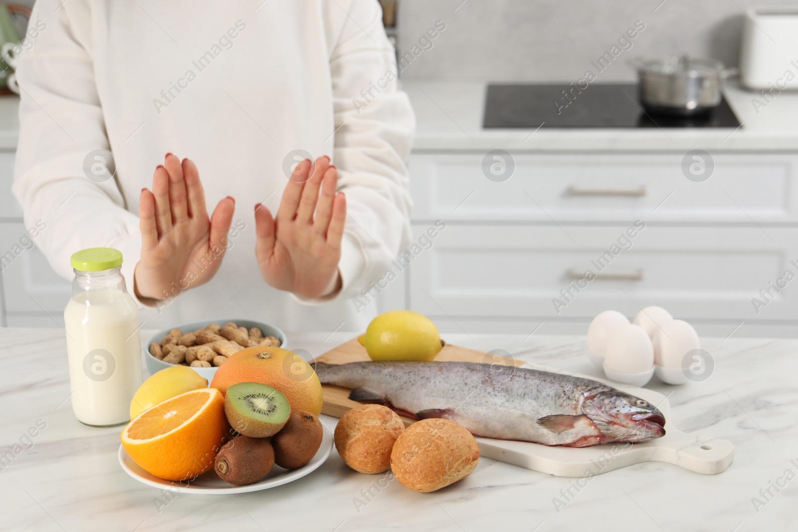 Photo of Woman suffering from food allergies refusing eat different fresh products at light table indoors, closeup