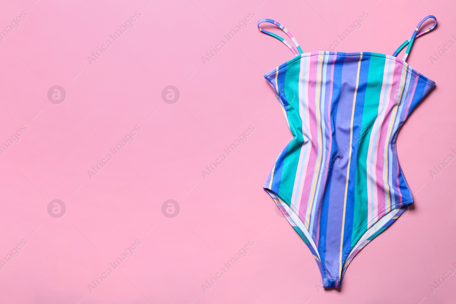 Photo of One-piece swimsuit on color background, top view