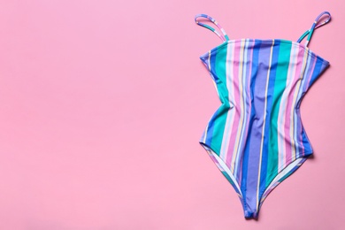 Photo of One-piece swimsuit on color background, top view