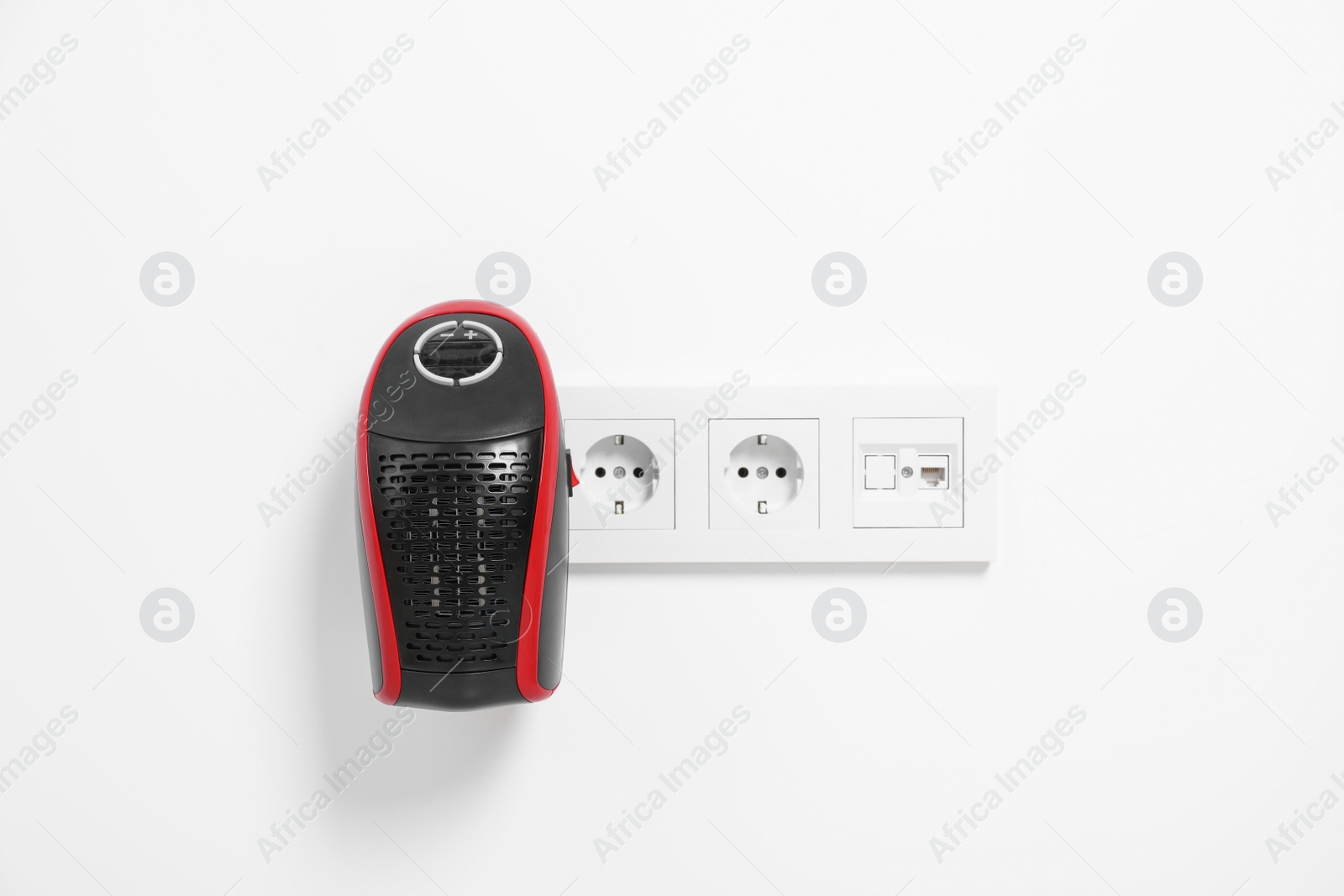 Photo of Portable electric heater on white wall indoors. Space for text