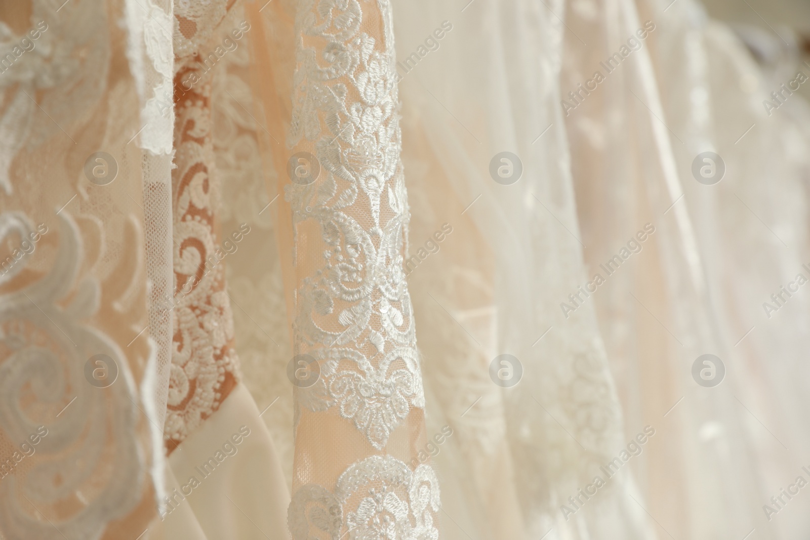 Photo of Different wedding dresses on hangers, closeup view
