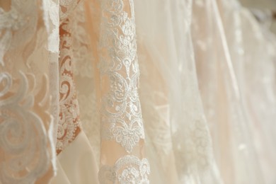 Photo of Different wedding dresses on hangers, closeup view