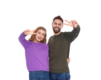 Photo of Happy young people showing victory gesture on white background