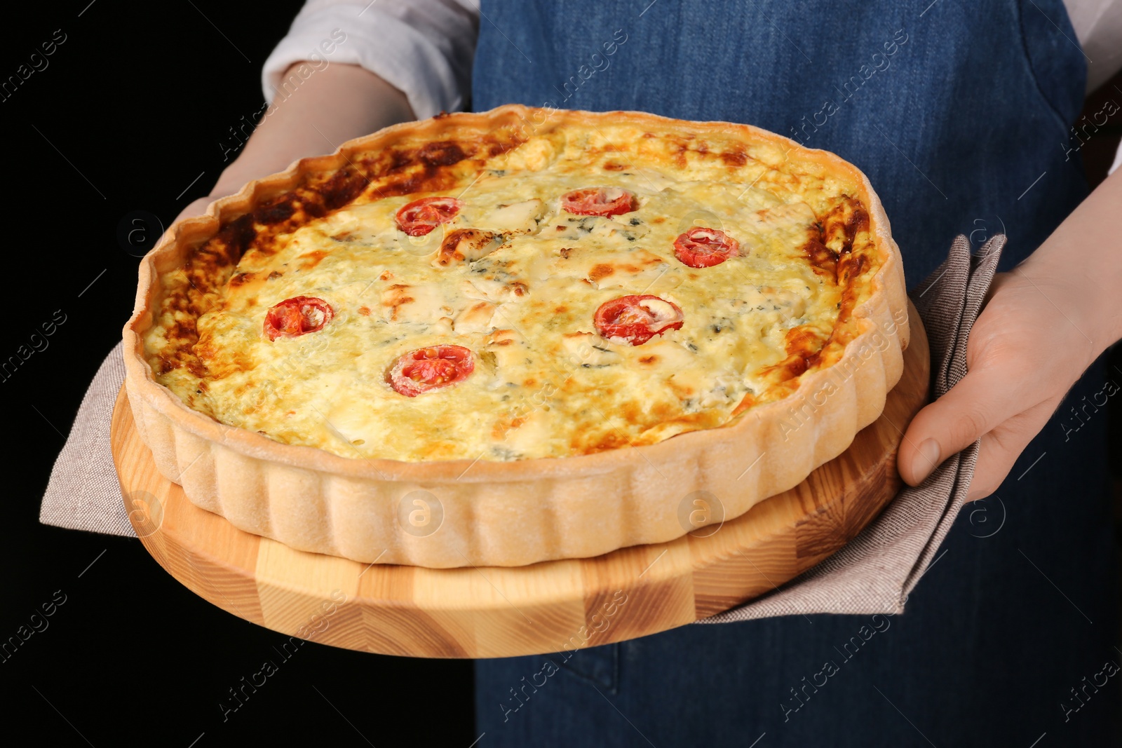 Photo of Woman with delicious homemade cheese quiche on black background, closeup