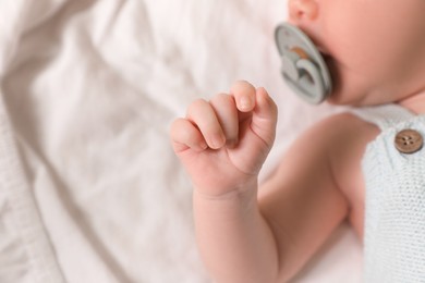 Photo of Cute newborn baby lying on bed, top view. Space for text