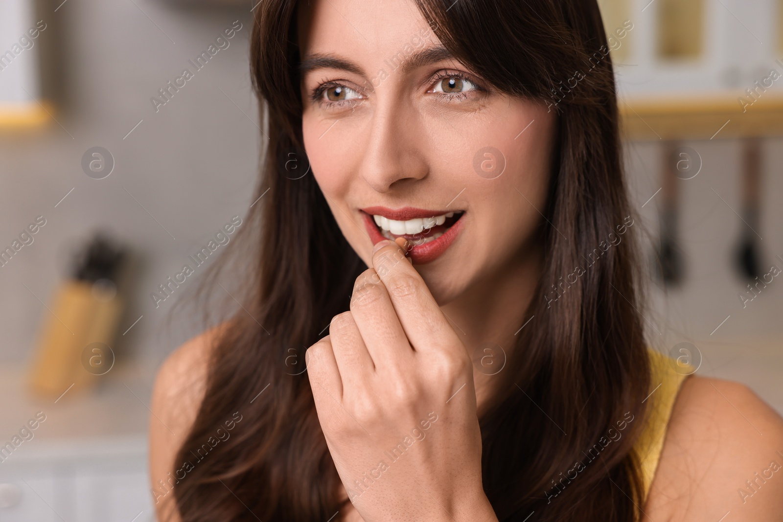 Photo of Beautiful woman taking vitamin pill at home