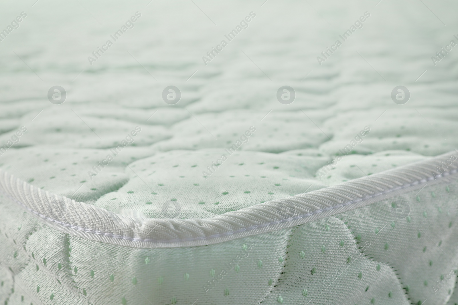 Photo of New light green mattress as background, closeup