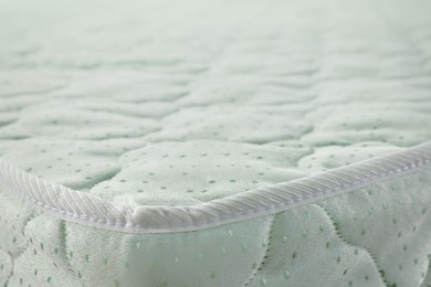 Photo of New light green mattress as background, closeup