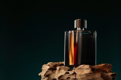 Photo of Luxury men`s perfume in bottle against dark background, space for text