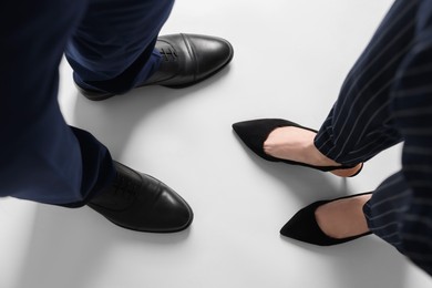 Businesswoman and businessman on white background, above view