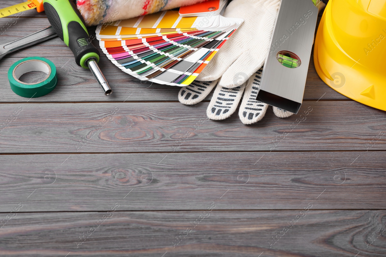 Photo of Different construction tools on grey wooden background. Space for text