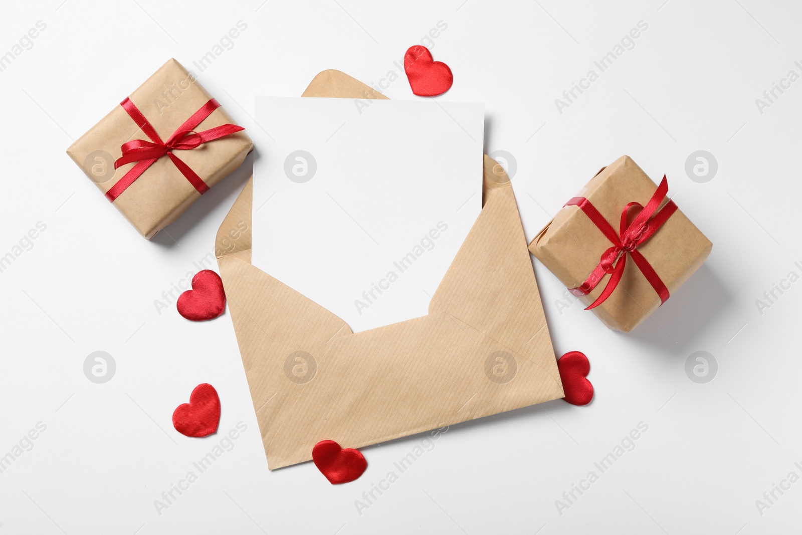 Photo of Blank card, envelope and gift boxes on white background, flat lay with space for text. Valentine's Day celebration